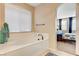 Relaxing bathroom with a large soaking tub and views into the bedroom at 8593 Garden Valley Ct, Las Vegas, NV 89178