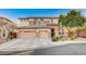 Two-story house with three-car garage, stone accents, and landscaping at 8593 Garden Valley Ct, Las Vegas, NV 89178