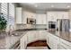 Modern kitchen with white cabinets, granite countertops, and stainless steel appliances at 8593 Garden Valley Ct, Las Vegas, NV 89178