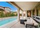 Covered patio with comfortable seating overlooking the refreshing pool at 8593 Garden Valley Ct, Las Vegas, NV 89178