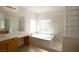 Elegant bathroom with a large soaking tub and glass block details at 8719 Mount Mira Loma Ave, Las Vegas, NV 89178