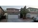 Two-story house with a white garage door and a palm tree in front at 9523 Cherrydale Ct, Las Vegas, NV 89147