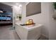 Bright bathroom featuring a modern soaking tub with bath caddy and a serene bedroom view at 138 Reflection Cove Dr, Henderson, NV 89011