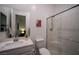 Bathroom featuring a tiled glass shower, white vanity, framed mirror, and neutral decor at 138 Reflection Cove Dr, Henderson, NV 89011