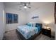 Cozy bedroom with a large window, ceiling fan, and a stylish blue patterned bedspread at 138 Reflection Cove Dr, Henderson, NV 89011