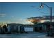 Modern single-story home with white garage door at dusk at 138 Reflection Cove Dr, Henderson, NV 89011