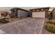 Front view of house, featuring a paved driveway and landscaping at 138 Reflection Cove Dr, Henderson, NV 89011