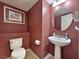 Updated bathroom with pedestal sink and burgundy walls at 1404 Crystal Rainey Ave, North Las Vegas, NV 89086