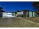 Midcentury modern home with a unique blue block wall facade and driveway at night at 1558 Aztec Way, Las Vegas, NV 89169