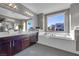 Elegant bathroom with double vanity, soaking tub, and large window at 232 Errogie St, Henderson, NV 89012