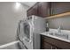 Modern laundry room with washer, dryer, and utility sink at 232 Errogie St, Henderson, NV 89012