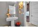 Stylish powder room with pedestal sink, modern mirror, and decorative accents at 232 Errogie St, Henderson, NV 89012