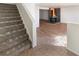 Carpeted stairs leading down to living area with fireplace at 2386 Pickwick Dr, Henderson, NV 89014