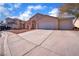 Two-story house with a three-car garage and landscaped yard at 2419 Country Valley Ct, North Las Vegas, NV 89030