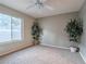 Spacious carpeted bedroom with a ceiling fan and large window at 2521 Seascape Dr, Las Vegas, NV 89128