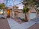 Tan stucco house with arched entryway, landscaping, and a two-car garage at 2521 Seascape Dr, Las Vegas, NV 89128