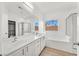 Clean bathroom with white cabinets, double sinks, and a soaking tub at 2812 Dotted Wren Ave, North Las Vegas, NV 89084