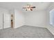 Simple bedroom with grey carpet, ceiling fan and access to bathroom at 2812 Dotted Wren Ave, North Las Vegas, NV 89084