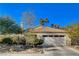 Spanish style house with white garage door and neatly landscaped yard at 301 Salinas Dr, Henderson, NV 89014