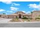 Single-story house with a tan exterior, a three-car garage, and landscaped front yard at 319 Hidden Highlands Dr, Las Vegas, NV 89110