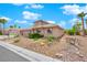 Single-story house with a tan exterior, a two-car garage, and landscaped front yard with a small bridge at 319 Hidden Highlands Dr, Las Vegas, NV 89110