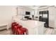 Modern kitchen island with red barstools and stainless steel appliances at 3772 Brilliant Sunset St, Las Vegas, NV 89129