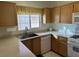 Well-lit kitchen with wood cabinets and stainless steel sink at 3810 Wiggins Bay St # 203, Las Vegas, NV 89129