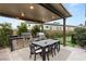 Modern outdoor kitchen with built-in grill and dining area at 5167 Rock Daisy Dr, Las Vegas, NV 89135