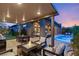 Covered patio with fire pit, dining area, and pool view at 5167 Rock Daisy Dr, Las Vegas, NV 89135