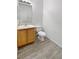 Clean bathroom, featuring a toilet and sink with wood cabinets at 5965 Palmilla St # 2, North Las Vegas, NV 89031