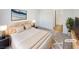 Virtually staged main bedroom with plush bed and access to bathroom at 5965 Palmilla St # 2, North Las Vegas, NV 89031