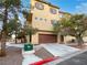 Tan three story townhome with attached garage and landscaping at 5965 Palmilla St # 2, North Las Vegas, NV 89031