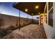 Cozy covered back patio with brick flooring, rock features, and well-kept landscape at 6289 Redstone Hills Dr, Las Vegas, NV 89148