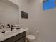 Modern half bathroom featuring a sleek vanity with a single sink and neutral decor at 6289 Redstone Hills Dr, Las Vegas, NV 89148