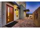 Inviting entryway with a modern orange door and brick paving at 6289 Redstone Hills Dr, Las Vegas, NV 89148