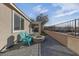 Cozy patio featuring a stone fire pit, turquoise chairs, and partial wall at 7017 Solana Ridge Dr, North Las Vegas, NV 89084