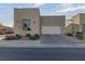 Modern home exterior featuring a two-car garage and manicured landscaping at 7017 Solana Ridge Dr, North Las Vegas, NV 89084