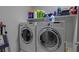 Practical laundry room with white washer and dryer units, and shelving at 7017 Solana Ridge Dr, North Las Vegas, NV 89084