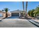 Single story home with a two car garage and desert landscaping at 7305 Backstretch Ave, Las Vegas, NV 89130