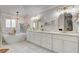 Elegant bathroom with double vanity, soaking tub, and marble floors at 7536 Spanish Bay Dr, Las Vegas, NV 89113