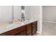 Double vanity bathroom with dark wood cabinets and light countertops at 7576 Windy Meadow Ave, Las Vegas, NV 89178