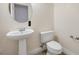 Small half bathroom with pedestal sink and toilet at 7645 Rustic Galleon St, Las Vegas, NV 89139