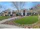 House exterior showcasing stone accents, landscaping, and a large lawn at 10032 Fox Springs Dr, Las Vegas, NV 89117