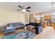 Cozy living area with comfortable sofas, a ceiling fan, and a view of the open-concept kitchen at 2112 Brighton Shore St, Las Vegas, NV 89128