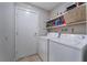 Functional laundry room with washer, dryer, and shelving for organized storage at 2690 Diamante Cir, Las Vegas, NV 89121