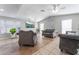 A spacious living room with a unique stone fireplace, modern lighting, and tile flooring at 2690 Diamante Cir, Las Vegas, NV 89121