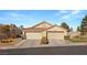 Tan two-car garage home with landscaped yard at 3090 Quail Crest Ave, Henderson, NV 89052