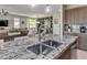 Granite island kitchen with double sink and modern pendant lighting at 4884 E Cactus Canyon Dr, Pahrump, NV 89061