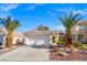 House exterior with a two-car garage and palm trees at 5558 Leaning Cloud Ct, Las Vegas, NV 89113