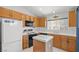 Kitchen with wood cabinets, island, and appliances at 5558 Leaning Cloud Ct, Las Vegas, NV 89113